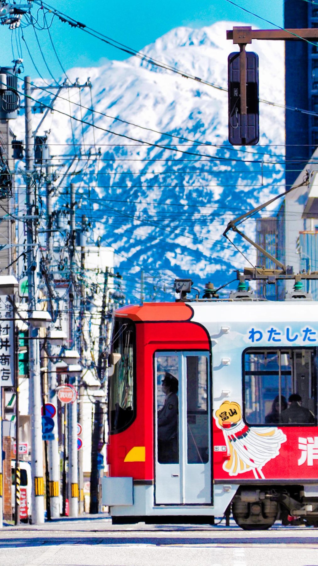 Toyama city tram along with the Tateyama Peaks